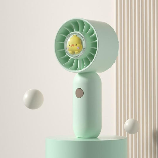 La main tient un petit ventilateur, un mini ventilateur de poche portable, style : canard vert